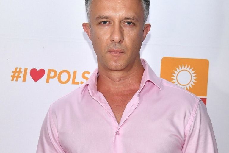 Łukasz Płoszajski w różowej koszuli