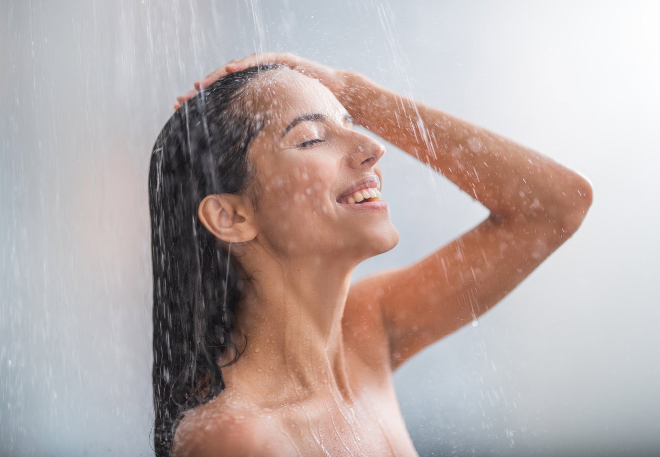 Positive woman taking hot shower