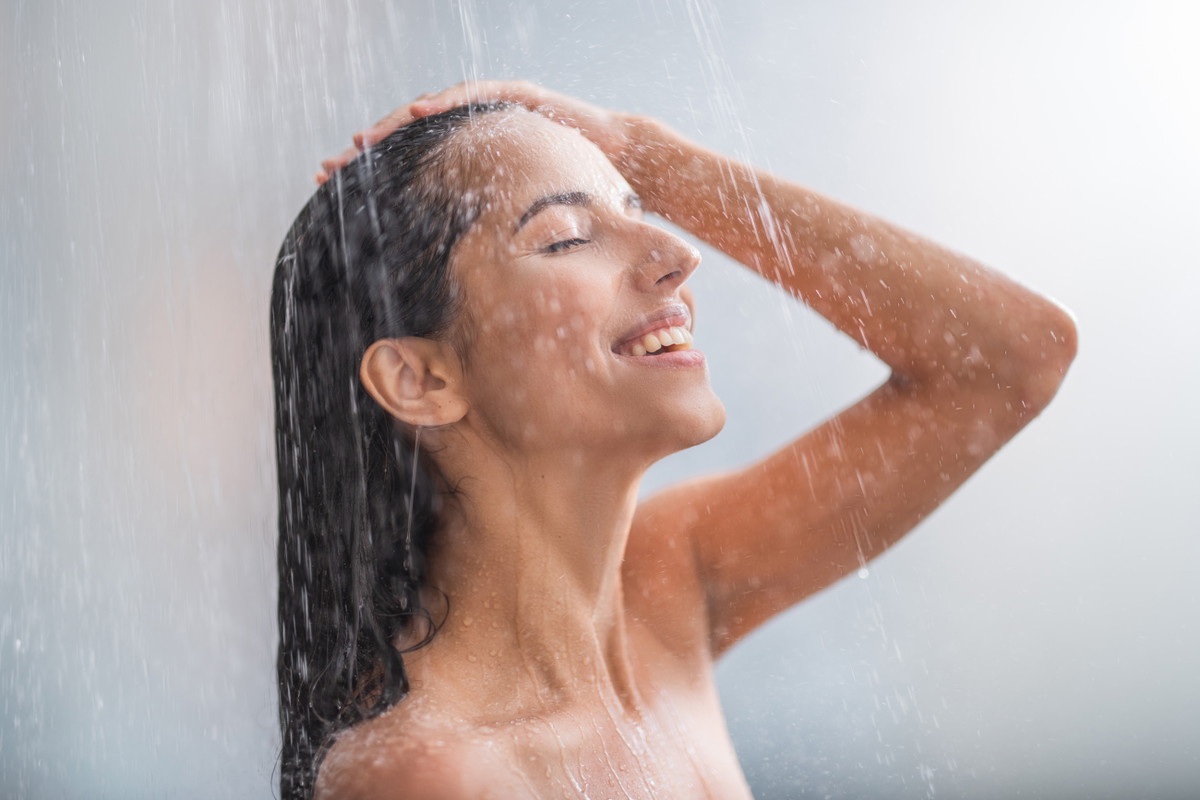 Positive woman taking hot shower