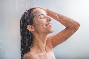 Positive woman taking hot shower