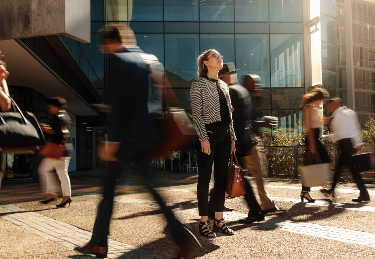 Businesswoman standing still on a busy street