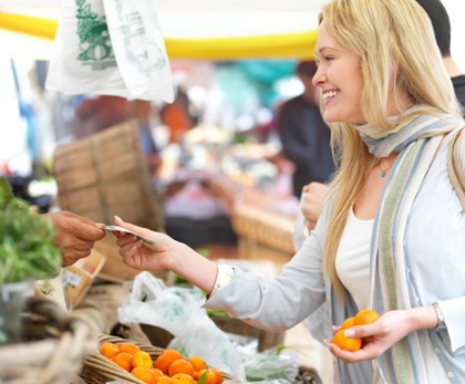 Happy blond woman buying food at market.