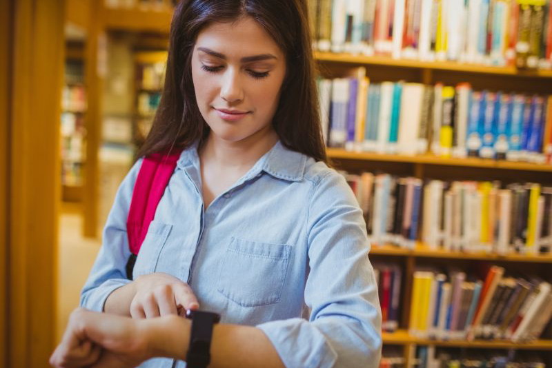 kobieta ze smartwatchem w bibliotece
