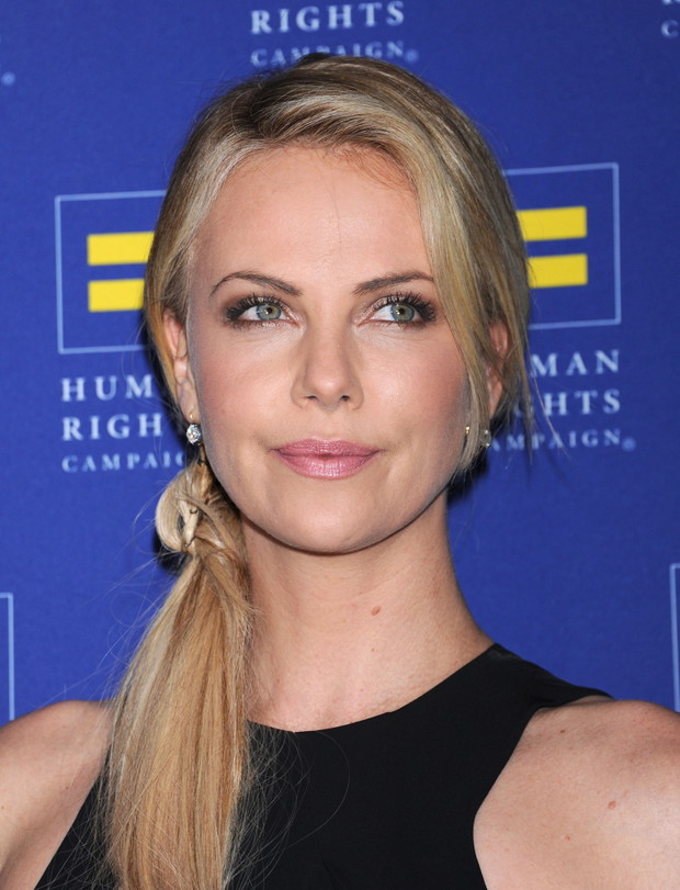 Charlize Theron w bardzo delikatnej fryzurze. Wlosy zostały zebrane w koński ogon i przewieszone z boku.