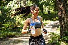 Young woman jogging outdoor on dirt road at the park .Green environment.