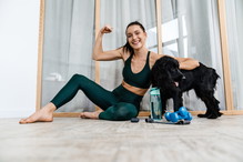 White brunette woman smiling and showing her bicep while working