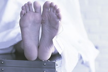 concept imitation morgue, coronavirus victim killed by 2019-ncov, legs of a corpse on a table, man died