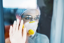 Quarantine during the virus outbreak at home or in a hospital, woman looking through the window