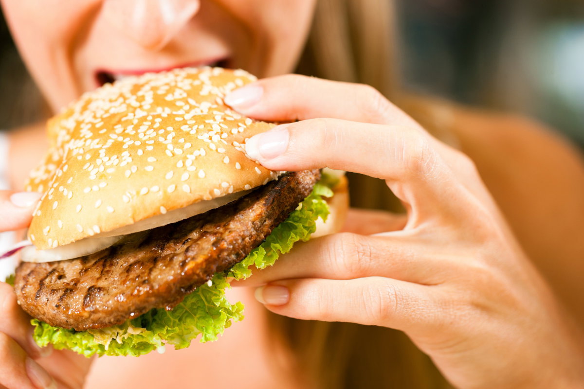 fast food w diecie, kobieta z hamburgerem