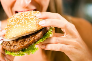 fast food w diecie, kobieta z hamburgerem