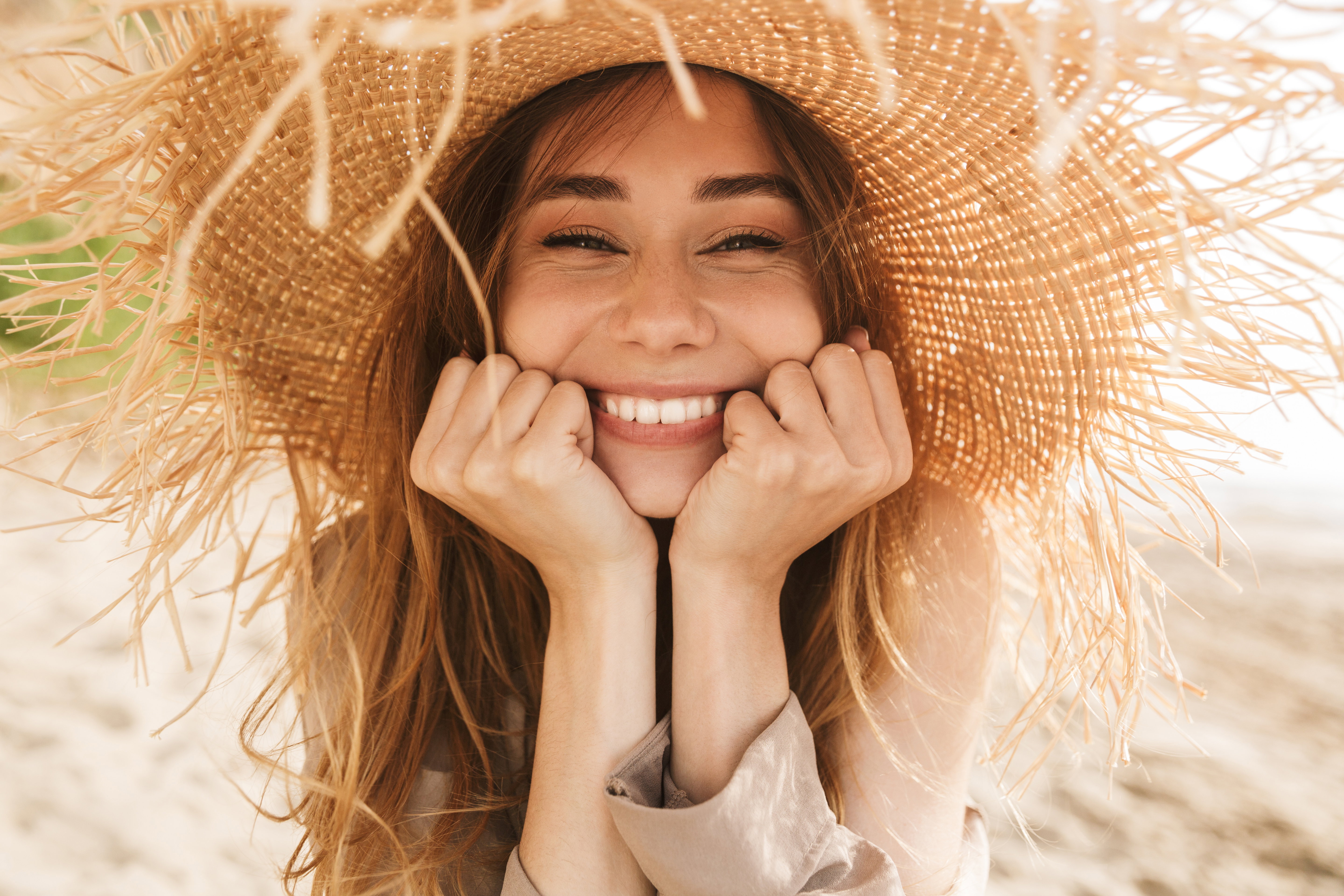 Pleased gorgeous attractive woman posing outdoors at the sea beach.