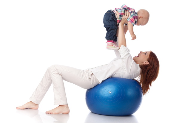 Mother and sweet small baby with fitness ball on a white background.