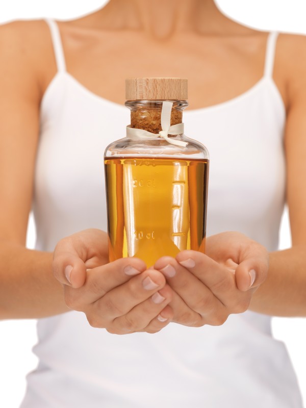 bright picture of female hands with oil bottle