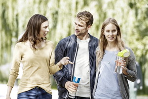 trzy osoby idą z butelkami Brita