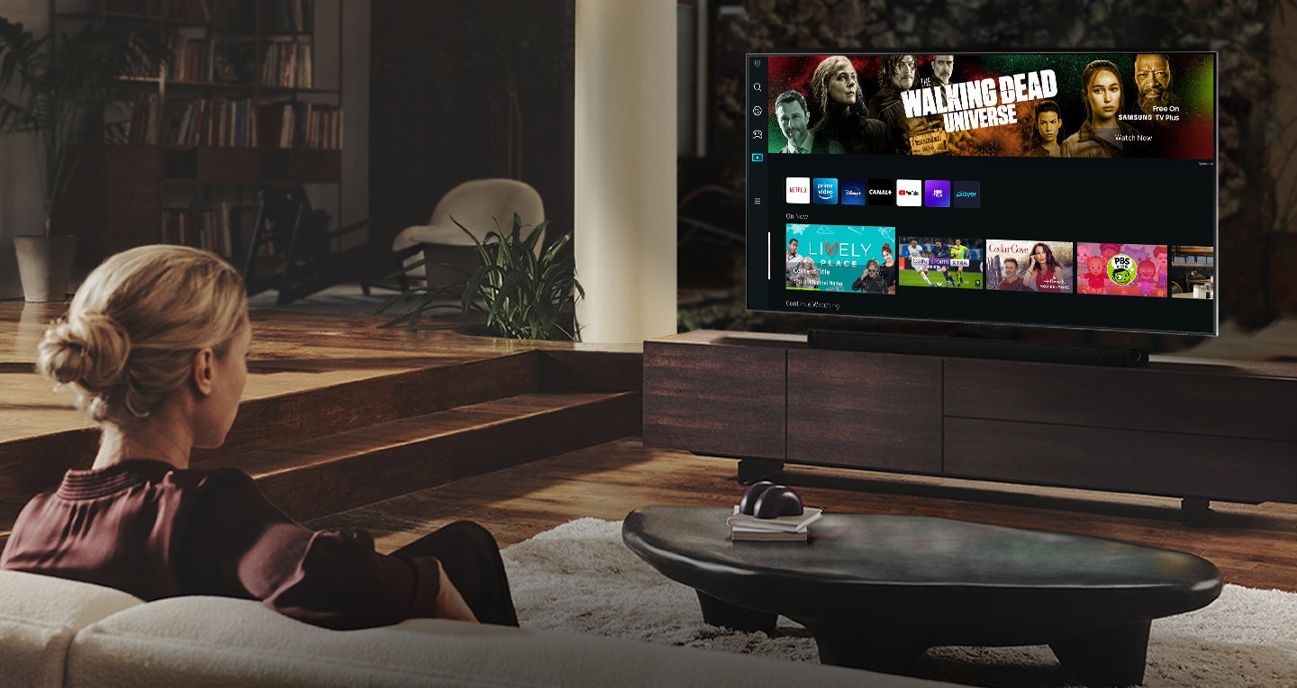 Kobieta ogląda ulubione programy na telewizorze dzięki funkcjom Smart TV