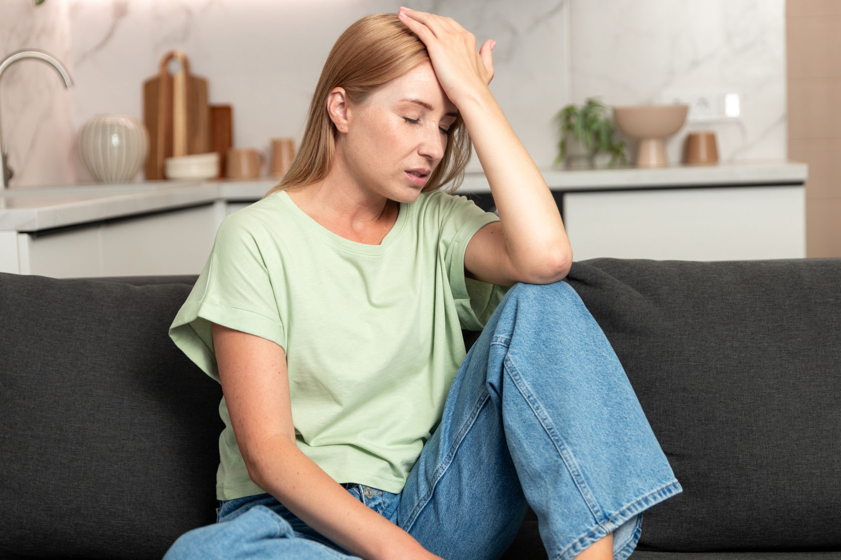 Tired young woman feeling pain from headache at home