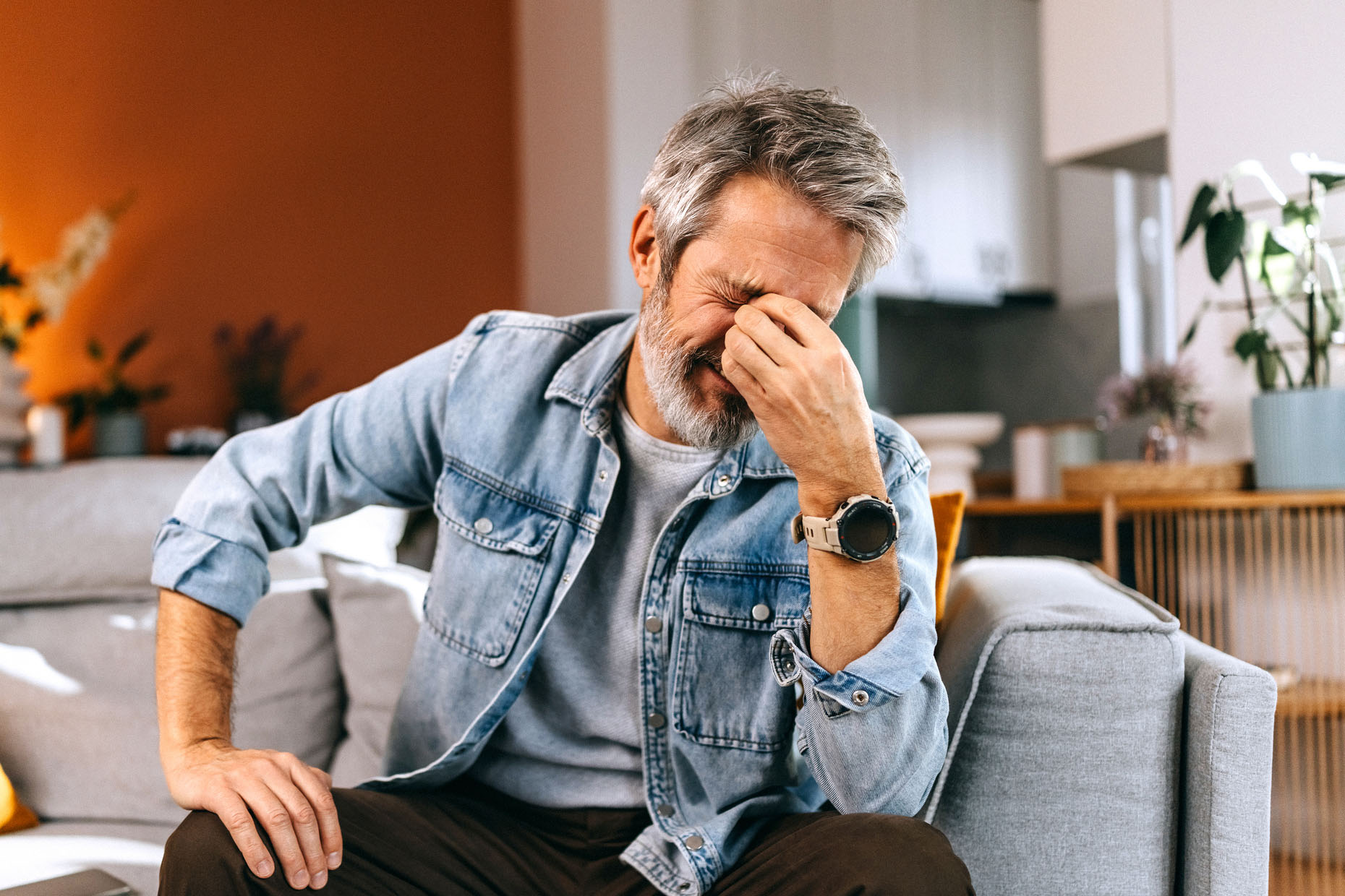 Stressed Senior Man Sitting on Sofa at Home
