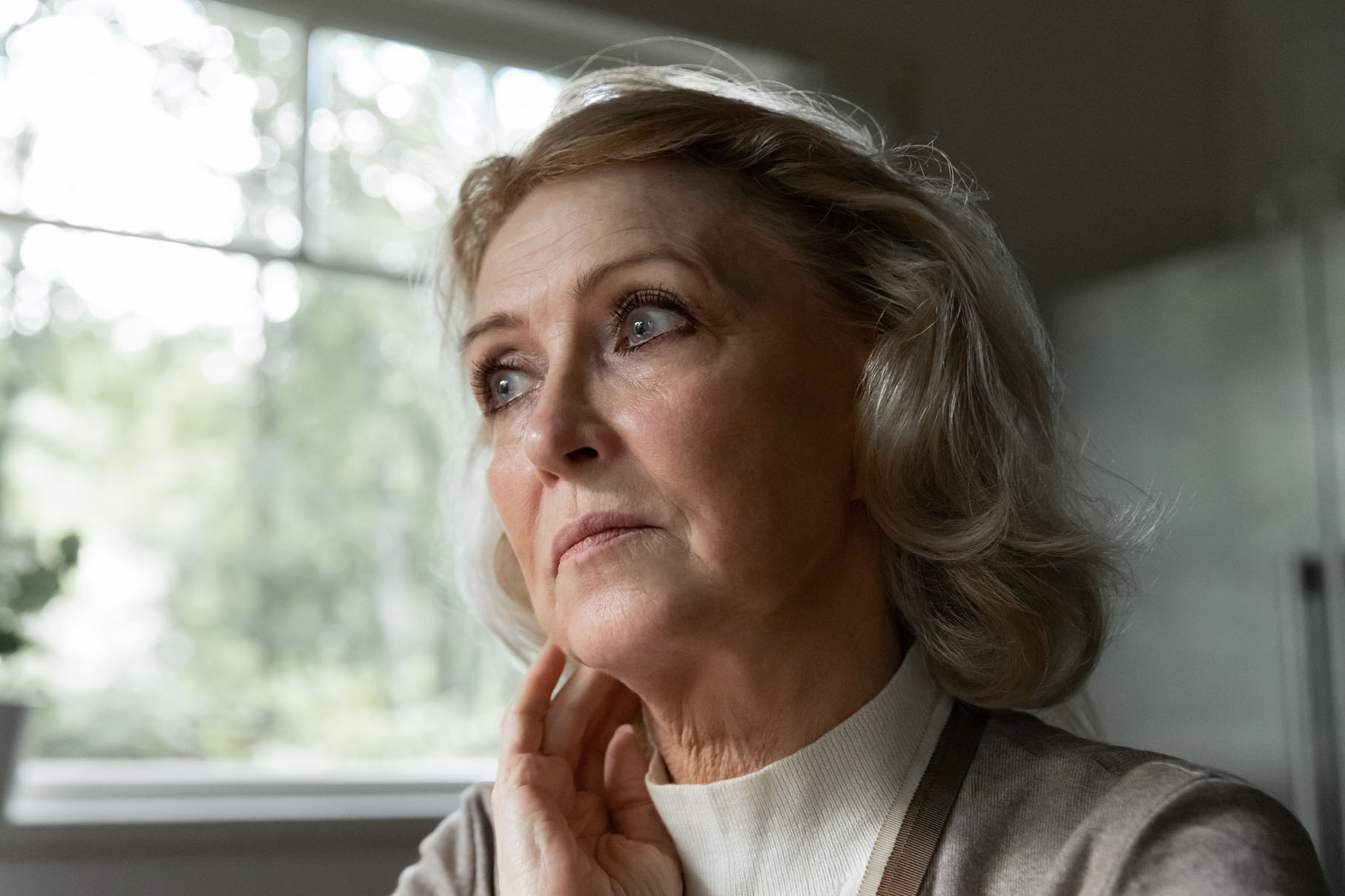 Close up thoughtful unhappy mature woman looking in distance