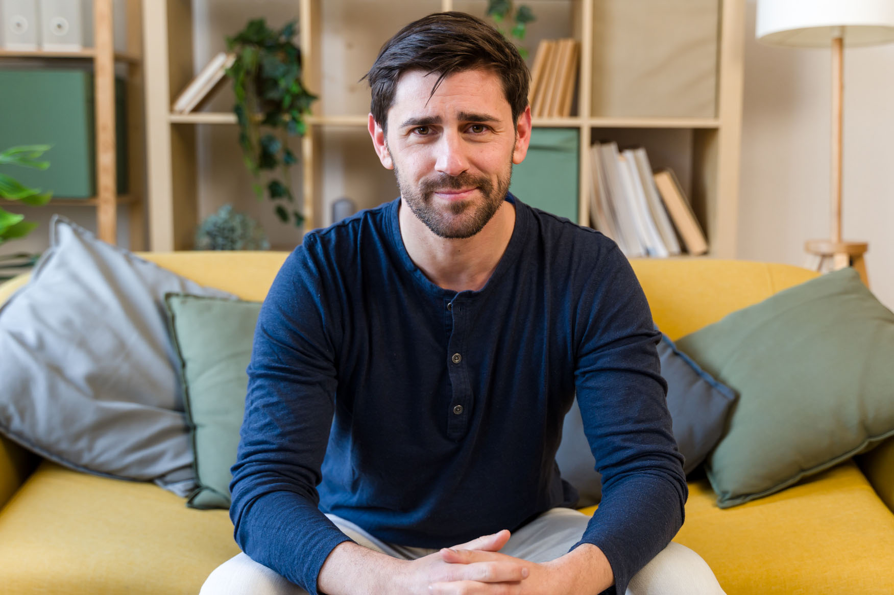 Man sitting on sofa looking at camera in living room