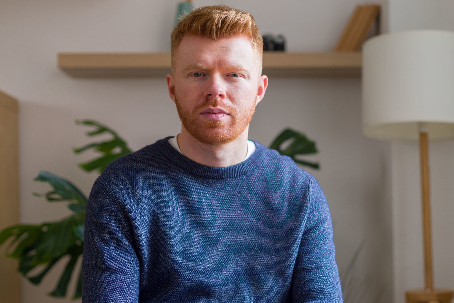 Serious young adult man sitting looking at camera