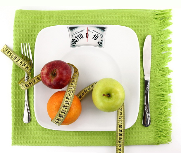Fruits with measuring tape on a plate like weight scale