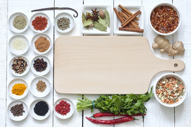 Spices and dried vegetables with cutting board on white planks