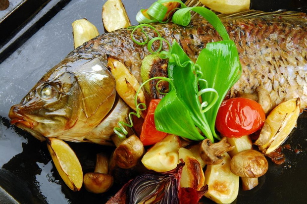 Baked fish with vegetables, mushrooms and lemon.