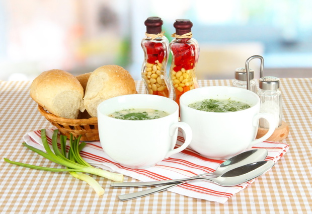 Fragrant soup in cups on table in kitchen