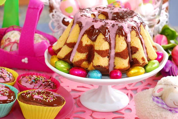 homemade marble ring cake poured chocolate sauce and pink icing on easter table