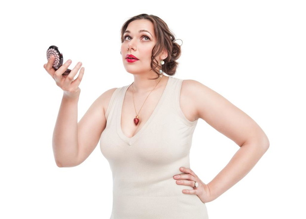 Beautiful plus size woman with mirror