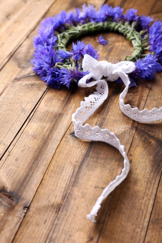 Fresh cornflower wreath on wooden background