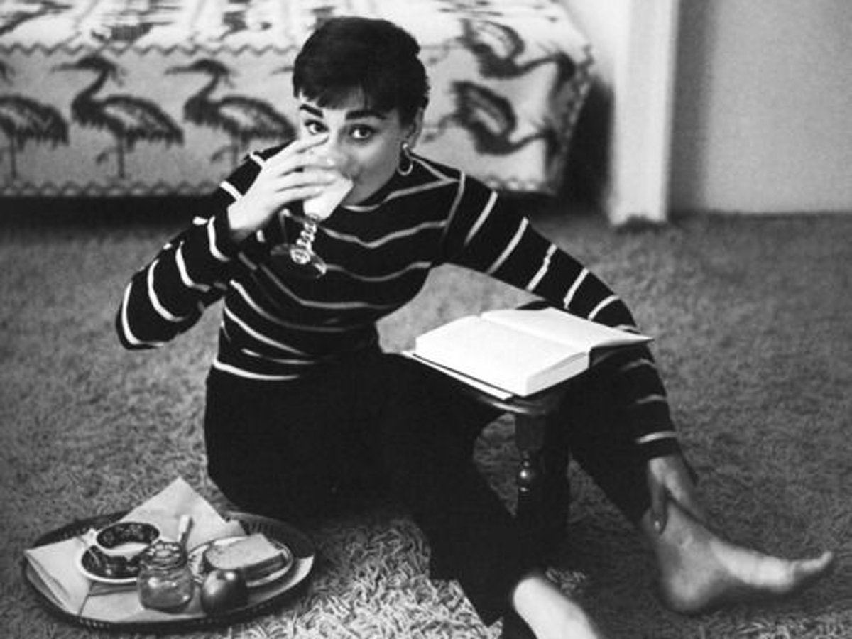 Audrey Hepburn podczas jedzenia i czytania książki