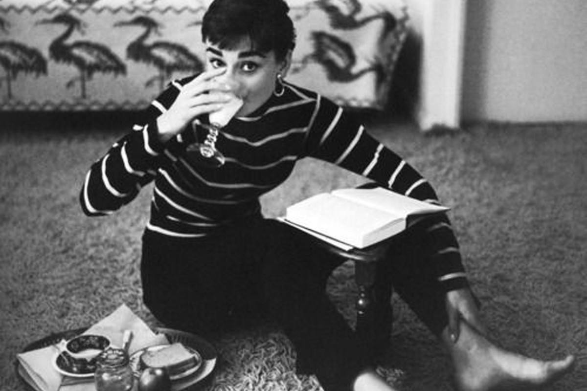 Audrey Hepburn podczas jedzenia i czytania książki