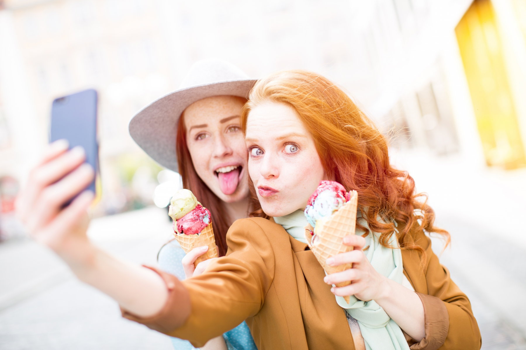 Kobiety jedzące lody w wafelku robiące sobie selfie