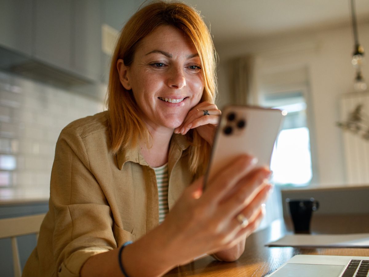Kobieta uśmiecha się do telefonu