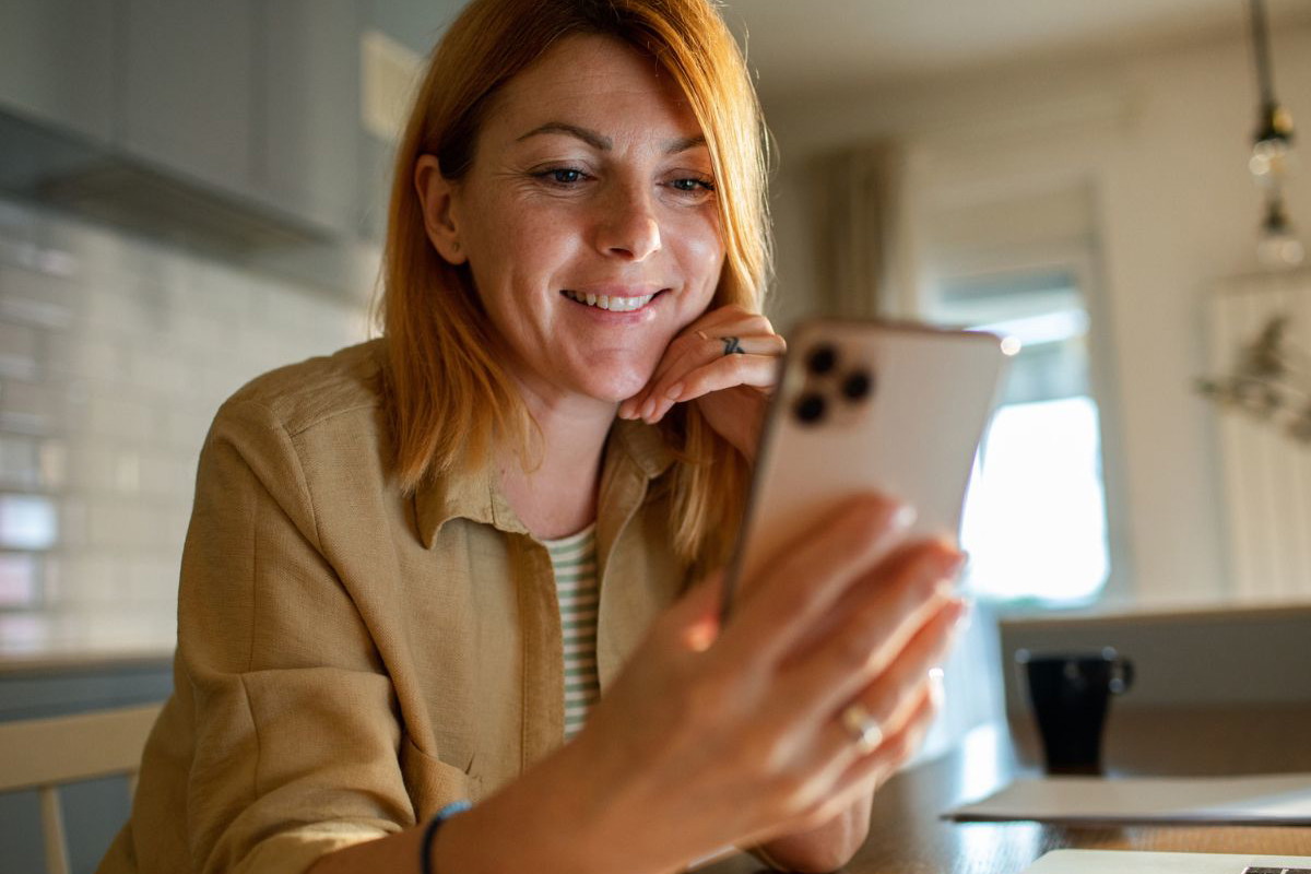 Kobieta uśmiecha się do telefonu