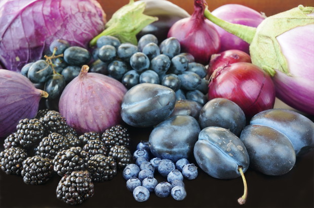 Blue and purple food. Berries, fruits and vegetables on a black