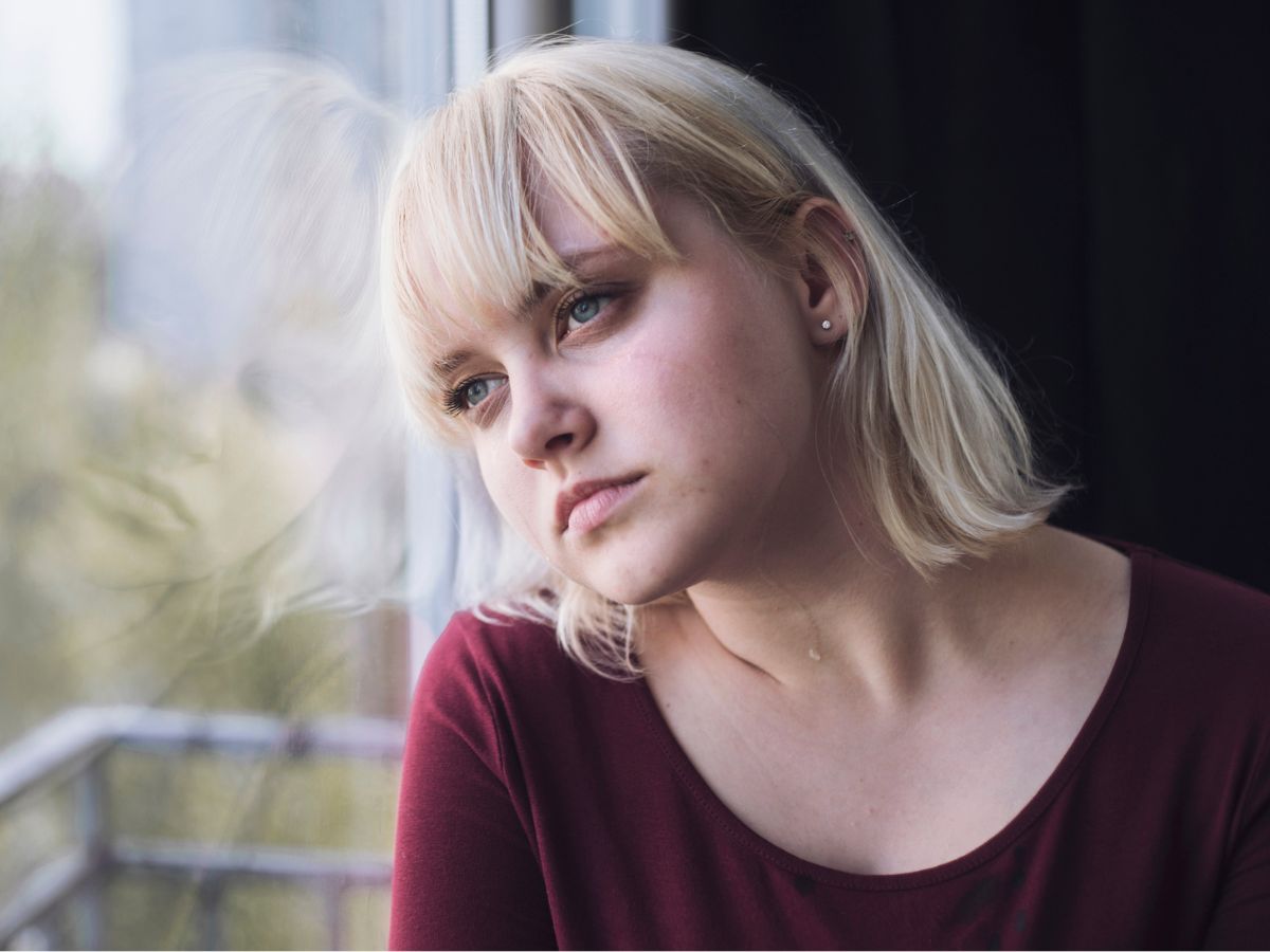 Smutna blondynka w oknie