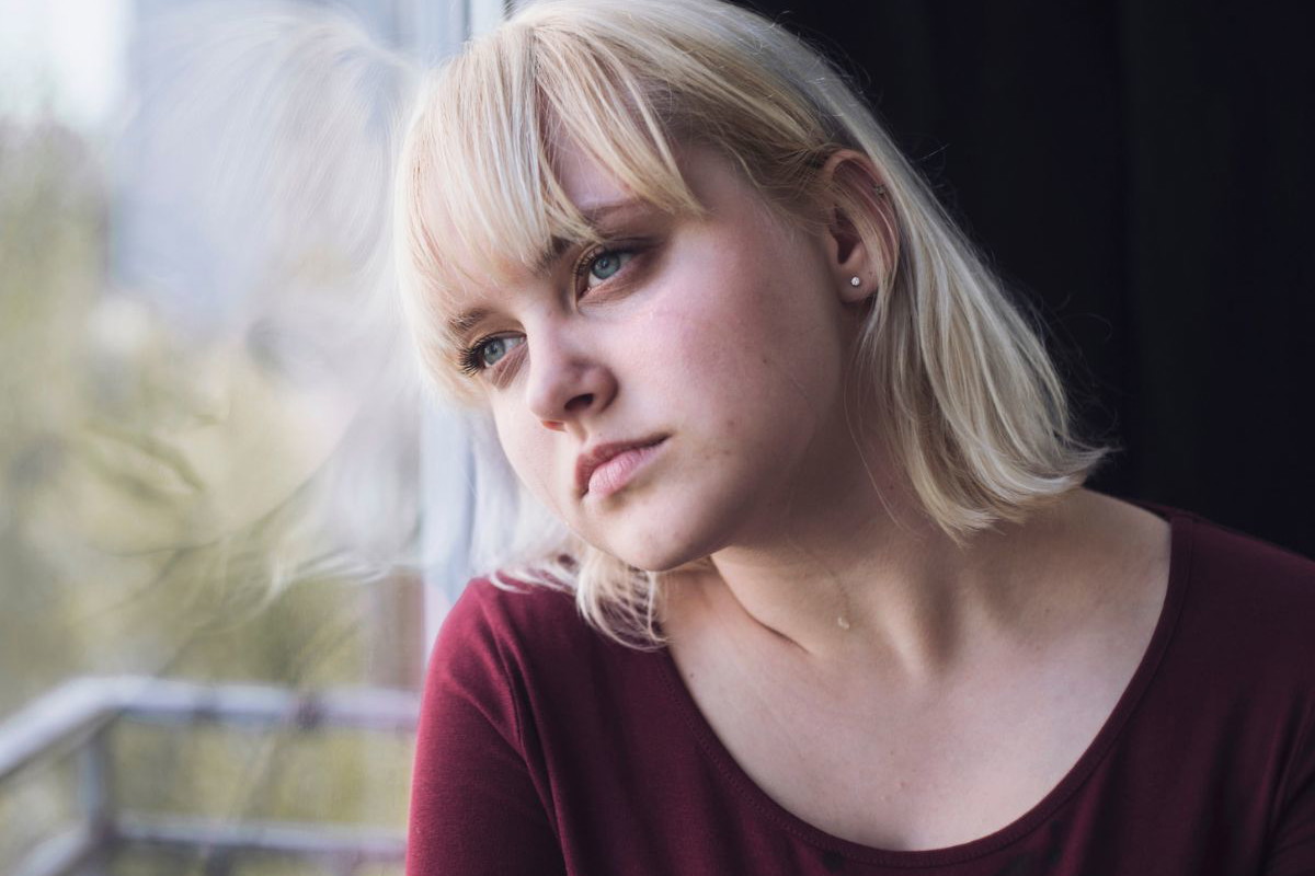 Smutna blondynka w oknie