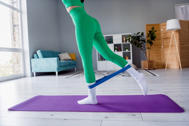 ćwiczenie pilatesu z taśmą na pośladki - unoszenie nogi w tył