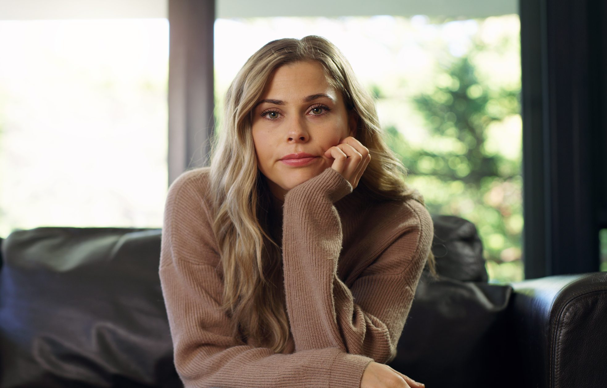 Portrait of bored woman on a living room sofa watching a boring tv show, movie or video. University or college student on school break with a free schedule sitting in a house, apartment or home