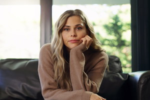 Portrait of bored woman on a living room sofa watching a boring tv show, movie or video. University or college student on school break with a free schedule sitting in a house, apartment or home