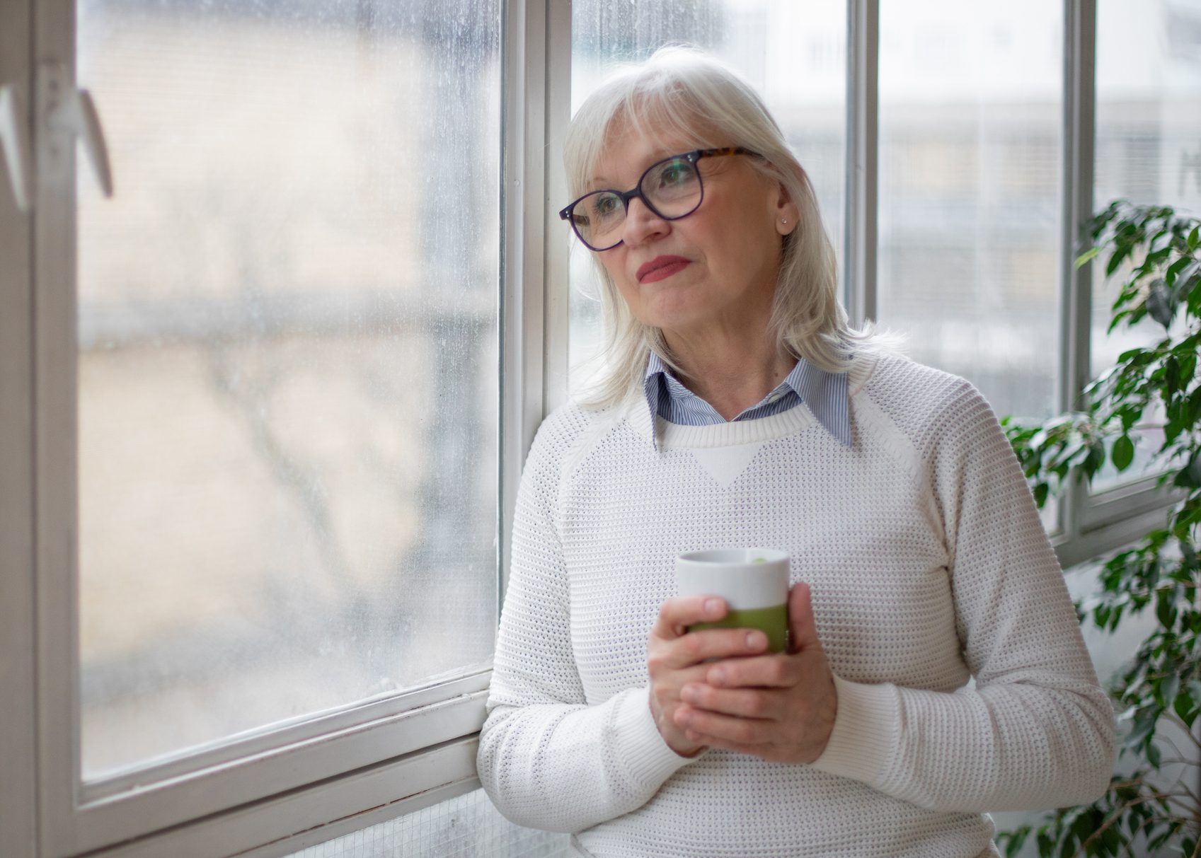 Portrait of a Mature Woman Standing by the Window