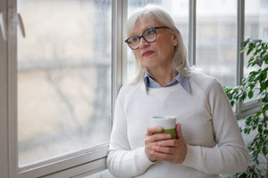 Portrait of a Mature Woman Standing by the Window