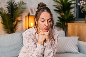 Sad Mid-Adult Woman Sitting At Home On The Sofa