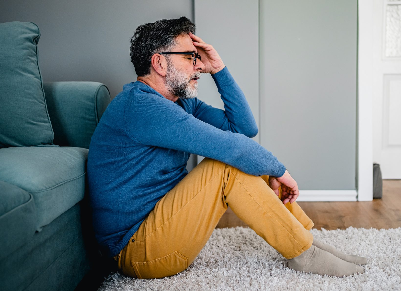 Depressed man sitting alone on the floor