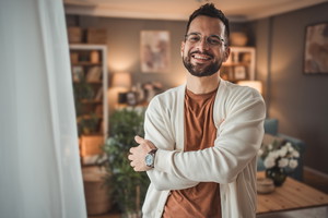 Portrait of confident and happy young man at home