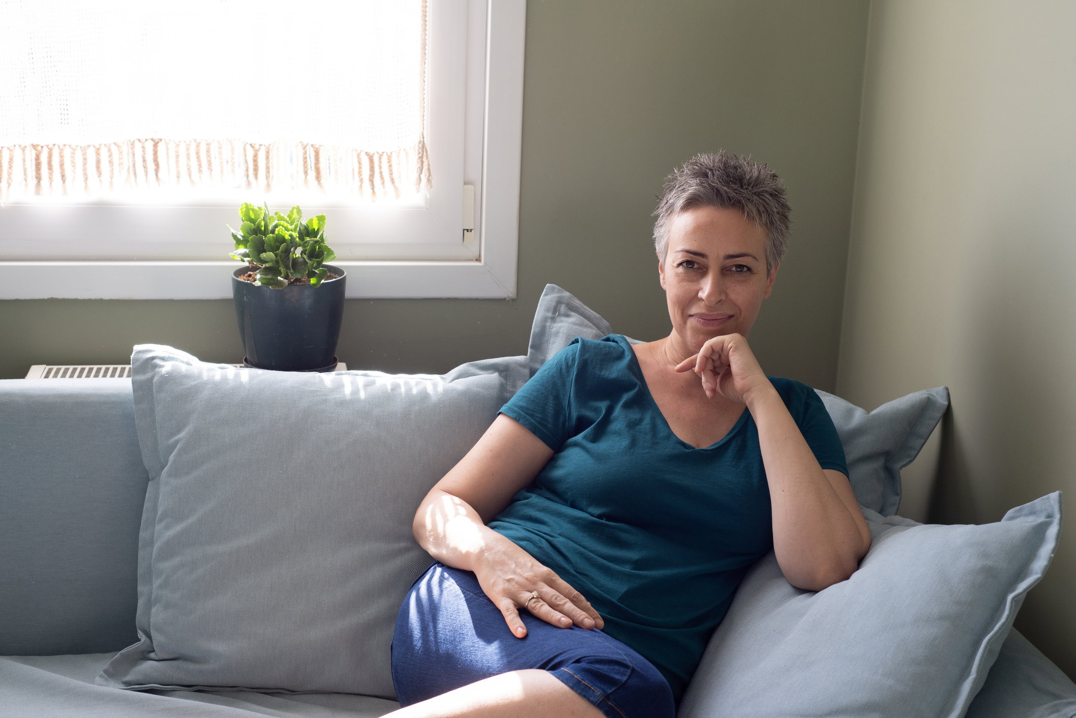 Portrait of smiling mature woman sitting on sofa