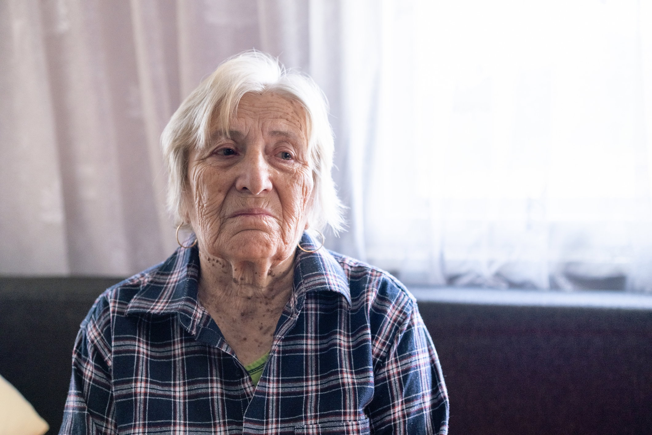 Portrait of desperate senior woman at home.