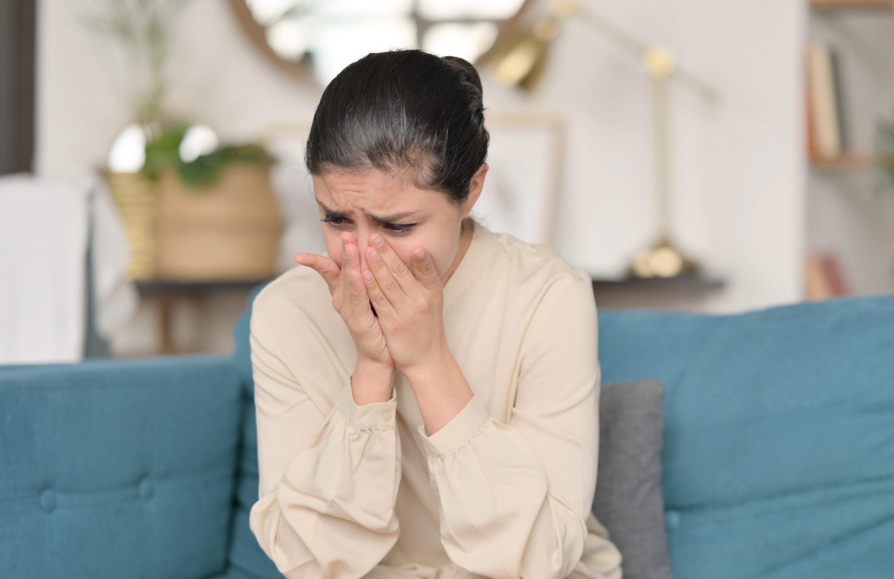 Young Indian Woman Sitting and Crying on Sofa